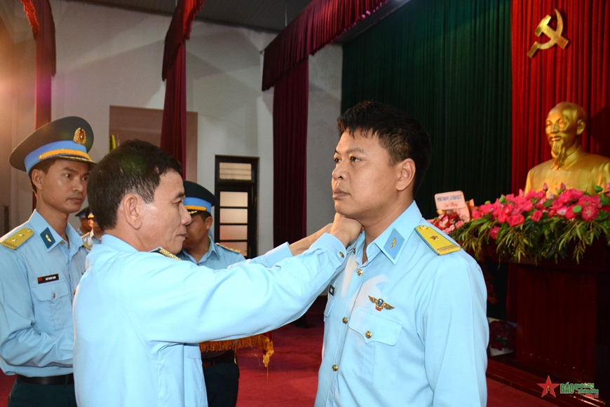 A person in a uniform putting on a person's neck

Description automatically generated