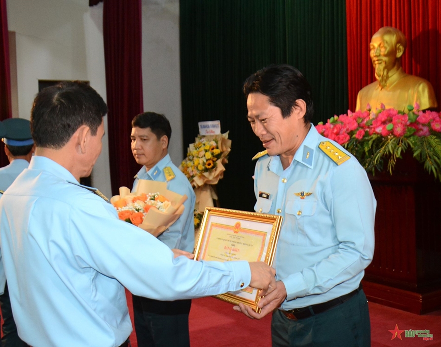 A person in uniform holding a certificate

Description automatically generated