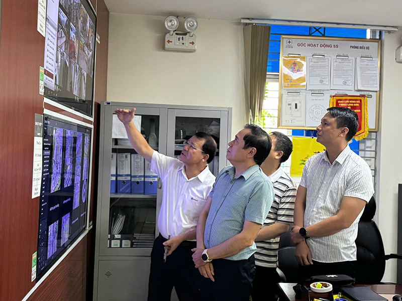 A group of men looking at a screen

Description automatically generated